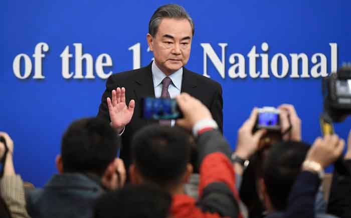 FILE: China's Foreign Minister Wang Yi waves to journalists as he arrives for a National People's Congress press conference in Beijing on 8 March 2019. Picture: AFP