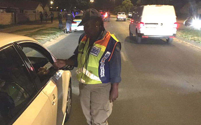 FILE: A JMPD official checks a driver's licence card during a police festive season operation on 20 December 2019. Picture: @WayneMinnaar2/Twitter
