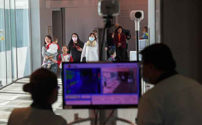 FILE: Health officers screen arriving passengers from China with thermal scanners at Changi International airport in Singapore on 22 January 2020 as authorities increased measure against coronavirus. Picture: AFP.