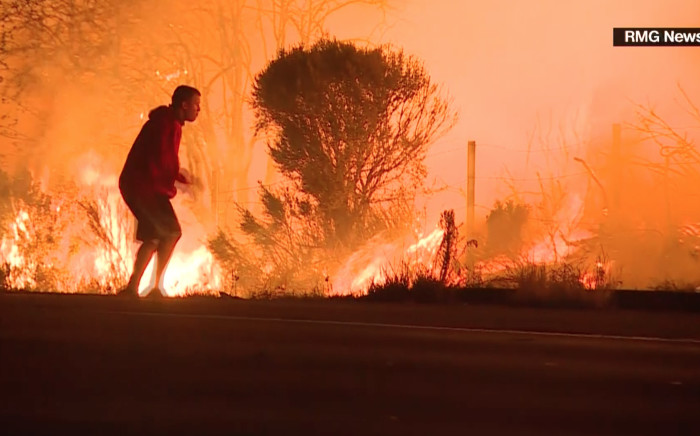FILE: A screengrab of a man rescuing a rabbit from a wildfire in California. Picture: CNN