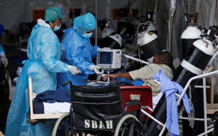 Professional healthcare workers wearing personal protective equipment (PPE) attend to a patient inside the temporary ward dedicated to the treatment of possible COVID-19 coronavirus patients at Steve Biko Academic Hospital in Pretoria on 11 January 2021. Picture: Phill Magakoe/AFP