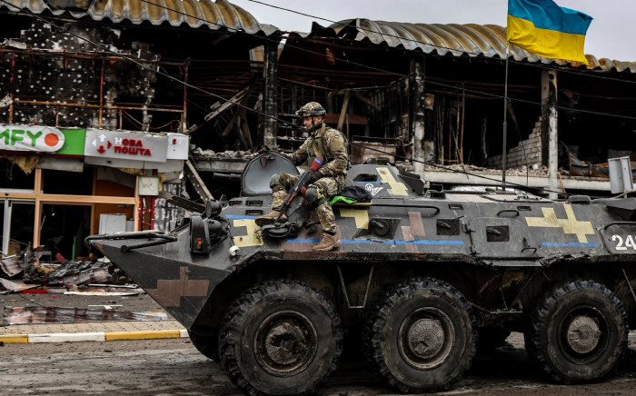 FILE: An Ukranian soldier patrols in an armoured vehicle a street in Bucha, northwest of Kyiv, on 2 April 2022, where the town's mayor said 280 people had been buried in a mass grave and that the town is littered with corpses. Picture: Ronaldo Schemidt/AFP