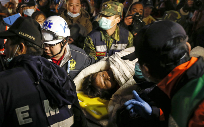 Rescuers carry a survivor who is trapped from a collapsed building following a 6.4 magnitude earthquake struck the area in Tainan City, southern Taiwan, 7 February 2016. Picture: EPA/RITCHIE B. TONGO