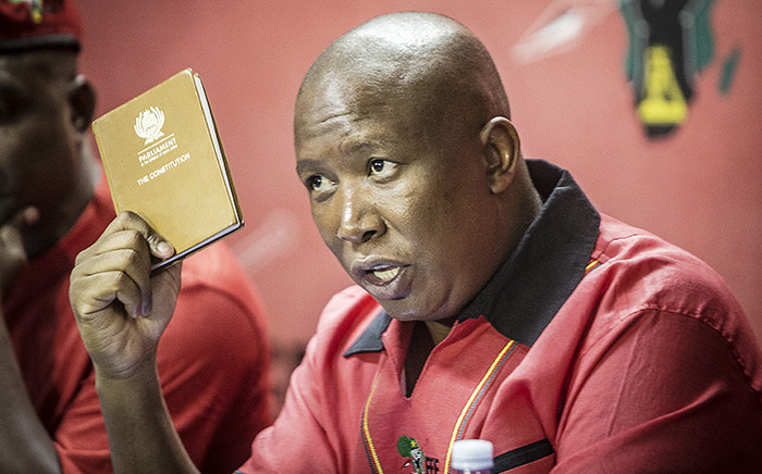 EFF leader Julius Malema holds up a copy of South Africa's constitution while addressing the media following the Constitutional Court's ruling that President Jacob Zuma must pay back some of the money spent on upgrades to his Nkandla homestead. Picture: Reinart Toerien/EWN.