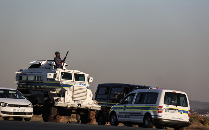 Police monitor the group of protesters in Protea Glen following illegal land grabs. Picture: Kayleen Morgan/EWN