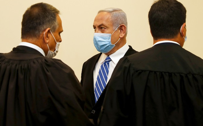 Israeli Prime Minister Benjamin Netanyahu (C), wearing a protective face maks, is pictured inside a courtroom at the district court of Jerusalem on 24 May 2020, during the first day of his corruption trial. Picture: AFP. 