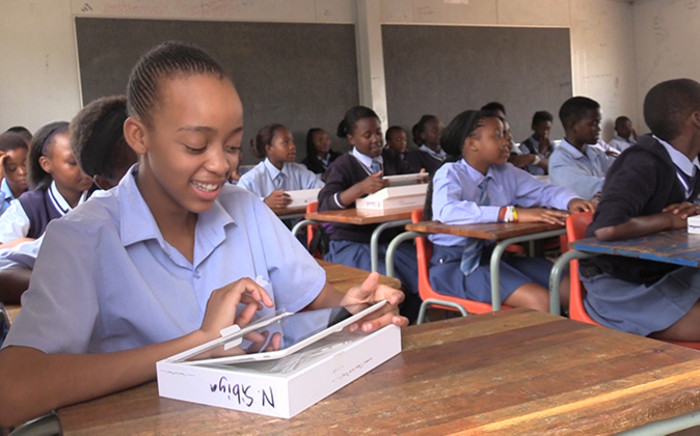 FILE: A Gauteng pupil smiles as she inspects her new tablet. Picture: EWN.