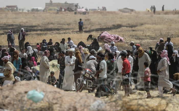 FILE: Syrian refugees wait between Syria and Turkish border as Turkish soldiers block them to pass the Turkish side. Picture: AFP.