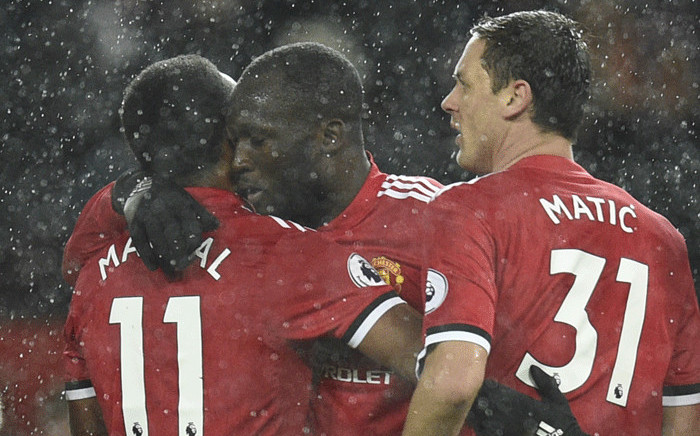 Manchester United's Belgian striker Romelu Lukaku embraces Manchester United's French striker Anthony Martial as he celebrates scoring their third goal during the English Premier League football match between Manchester United and Stoke City at Old Trafford in Manchester, north west England, on 15 January, 2018. Picture: AFP.