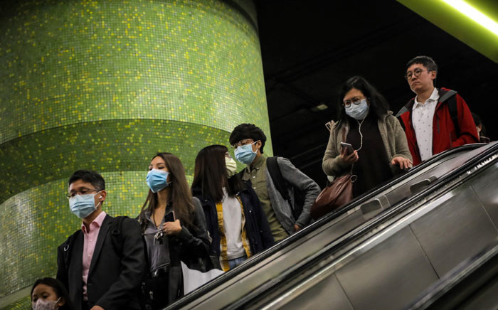 Commuters wearing face masks as a precautionary measure to protect against the possible spread of a SARS-like virus outbreak ride an escalator at an MTR subway station ahead of the Chinese New Year in Hong Kong on 23 January 2020. Picture: AFP