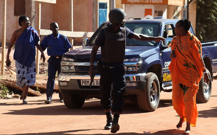 Malian security forces evacuate two women from an area surrounding the Radisson Blu hotel in Bamako on 20 November, 2015. Gunmen went on a shooting rampage at the luxury hotel in Mali's capital Bamako, seizing 170 guests and staff in an ongoing hostage-taking that has left at least three people dead. Picture: AFP.