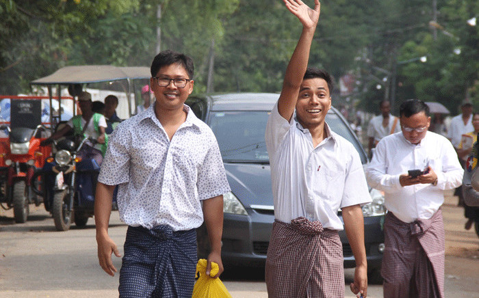 Reuters journalists Kyaw Soe Oo (C) waves beside colleague Wa Lone (L) as they walk out of Insein prison after being freed in a presidential amnesty in Yangon on 7 May 2019. Picture: AFP.