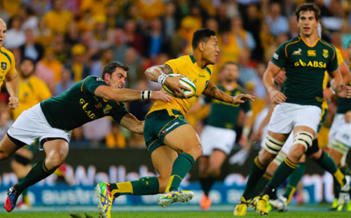 Australian fullback Israel Folau is tackled by South African scrum half Francois Louw during the Rugby Championship match at Suncorp Stadium in Brisbane on 7 September 2013. Picture: AFP/Patrick Hamilton