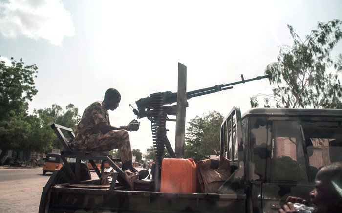 FILE: A boy looks on as a soldier sits on the back of an armed vehicle in Maiduguri in north-eastern Nigeria on 7 July 2017. Picture: AFP