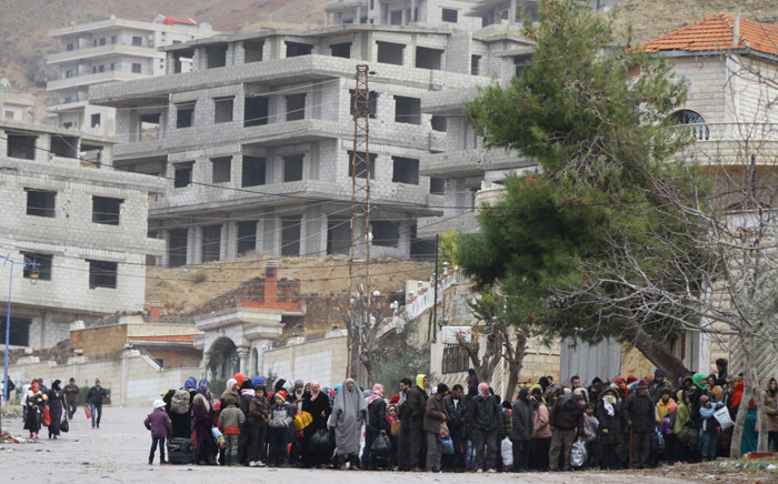FILE: Residents of the besieged rebel-held Syrian town of Madaya wait for a convoy of aid from the Syrian Arab Red Crescent on 14 January 2016. Picture: AFP.
