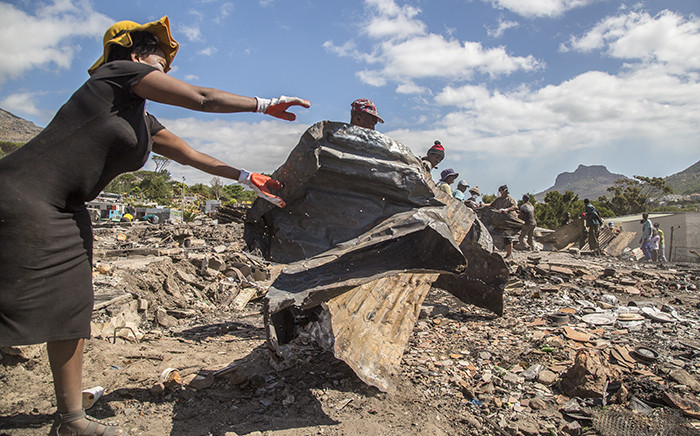 "Residents of the Imizamo Yethu informal settlement in Hout Bay, Cape Town, help to clear the rubble on 28 December 2015 after a fire ripped through a section. Picture: Aletta Harrison/EWN.