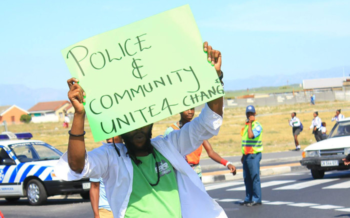 FILE: An activist carry a placard he protests against policing in Khayelitsha. Picture: Ndifuna Ukwazi Facebook page.