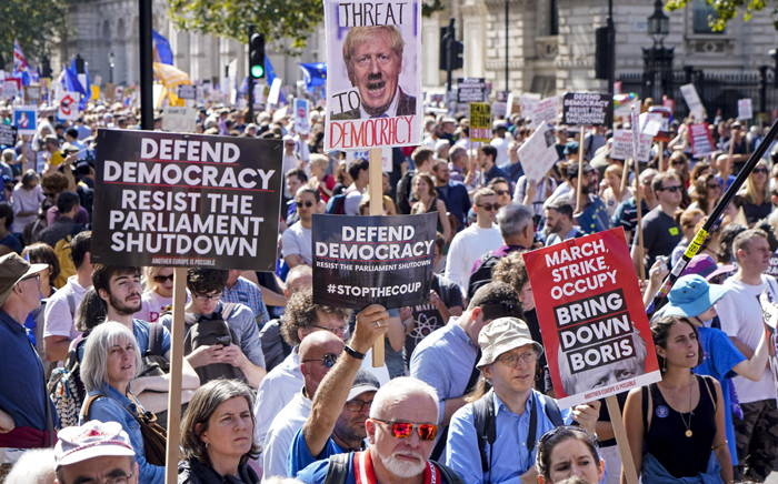 Demonstrators hold up placards in the sunshine at a protest against the move to suspend parliament in the final weeks before Brexit outside Downing Street in London on 31 August 2019. Picture: AFP.