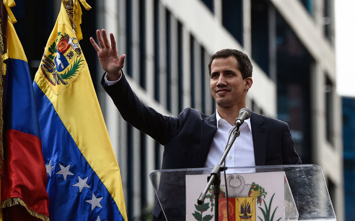 Venezuela's National Assembly head Juan Guaido waves to the crowd during a mass opposition rally against leader Nicolas Maduro in which he declared himself the country's "acting president", on the anniversary of a 1958 uprising that overthrew military dictatorship, in Caracas on 23 January 2019. Picture: AFP
