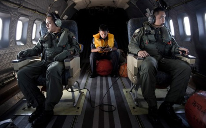 FILE: Crew members look out the windows from a Malaysian Air Force CN235 aircraft during a search and rescue operation to find the missing Malaysia Airlines flight MH370 plane over the Strait of Malacca on 14 March 2014. Picture: AFP.