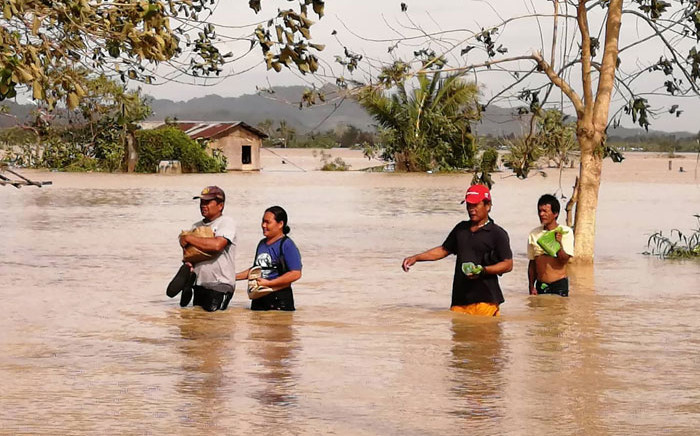 Residents wade through a flooded highway, caused by heavy rains due to Typhoon Phanfone, in Ormoc City, Leyte province in central Philippines on 25 December 2019. Picture: AFP