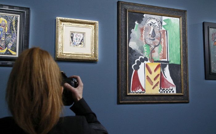 A photographer takes photos of the works "La Fenetre de l’atelier La Californie" and "Buste d'homme" by Pablo Picasso during the Sotheby's auction on 23 October 2021 in Las Vegas. Picture: AFP