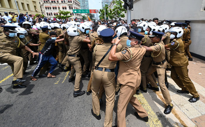 Government supporters and police clash outside the President's office in Colombo on 9 May 2022. Violence raged across Sri Lanka late into the night on 9 May 2022, with five people dead and some 180 injured as prime minister Mahinda Rajapaksa quit after weeks of protests. Picture: Ishara S. KODIKARA/AFP