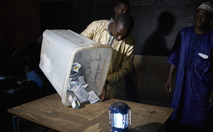 FILE: An election official overturns a box containing ballot papers during the vote counting at a polling station in Bamako on 12 August 2018, after the second round of Mali's presidential elections. Picture: AFP.