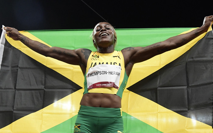 Jamaica's Elaine Thompson-Herah celebrates with the flag of Jamaica after winning the women's 100m final during the Tokyo 2020 Olympic Games at the Olympic Stadium in Tokyo on July 31, 2021. Piture: Javier SORIANO / AFP