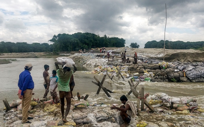 Locals gather concrete fragments and heavy bags wrapped in nets to build a dam as floodwaters flow from the north into the state of Indian eastern state of Bihar near Muzaffarpur on 13 July 2019. Picture: AFP