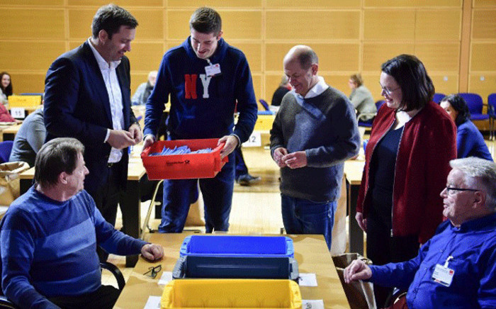 Secretary-General of the Social Democratic Party (SPD) Lars Klingbeil (2nd L) and Social Minister Andrea Nahles (2nd R) react as a volunteer (3rd L) brings the ballots to be counted at the headquarters of Germany's social democratic SPD party in Berlin on 3 March, 2018, as SPD members voted on whether or not to join a new coalition government with German Chancellor Angela Merkel's conservatives. Picture: AFP.