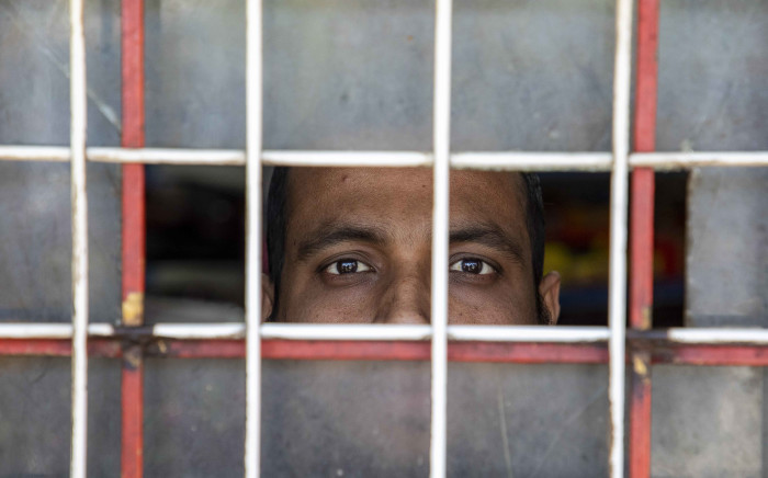 Faiz Ahmed, a Bangladeshi business owner in Jeppestown braves the looting to open his shop and sell what he can for a few hours during the day from behind bars. Picture: Thomas Holder/EWN.
