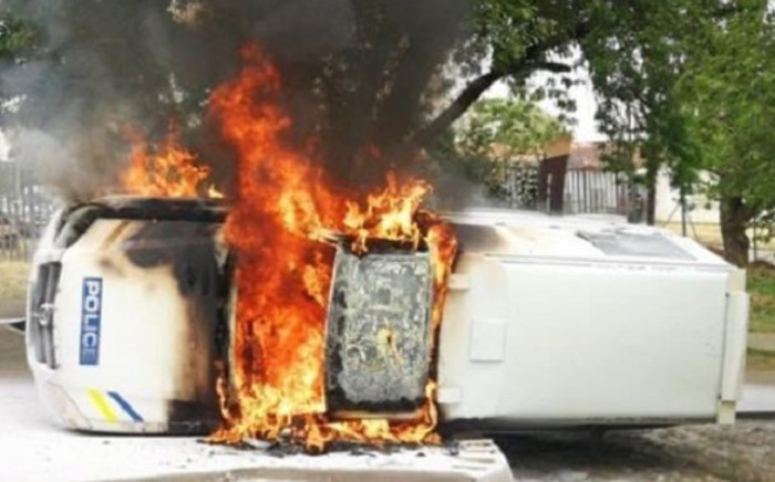 FILE: A police vehicle set alight by angry farmers outside the Senekal Magistrate’s Court on 6 October 2020. Picture: @crimeairnetwork/Twitter
