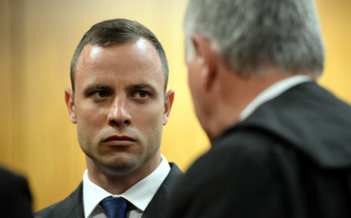 Oscar Pistorius talks to defence advocate Barry Roux before the start of court proceedings of his murder trial on 24 March 2014 at the High Court in Pretoria. Picture: Pool.