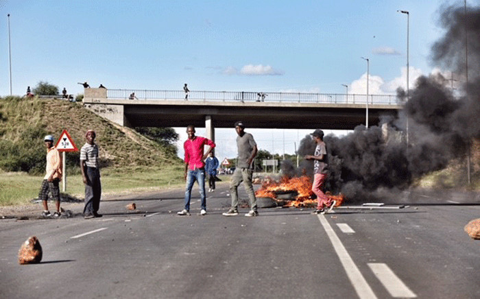 Protesters from Top Village township can be seen blocking the main road leading into Mahikeng as they call for the removal of Premier Supra Mahumapelo. Picture: Ihsaan Haffejee/EWN
