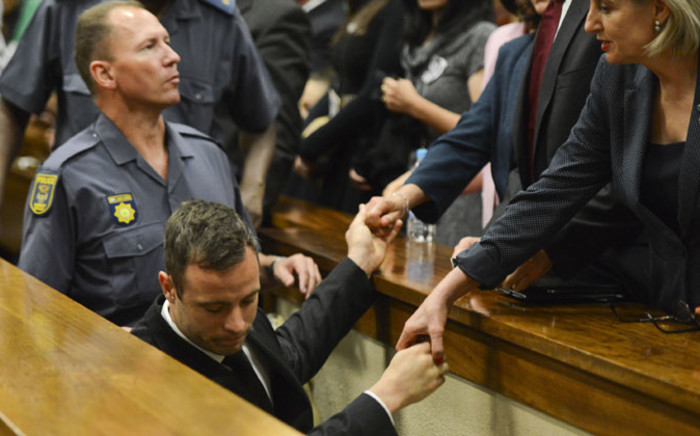Oscar Pistorius holds the hands of family members as he is taken down to the holding cells after being sentenced to five years imprisonment for the culpable homicide killing of his girlfriend Reeva Steenkamp at the high court in Pretoria on 21 October 2014. Picture: Pool.