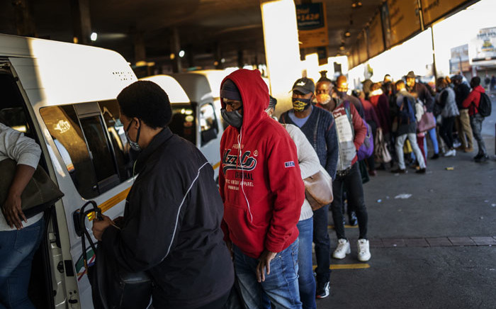 Commuters wait to enter their taxi at Bree taxi rank in Johannesburg. Picture: AFP