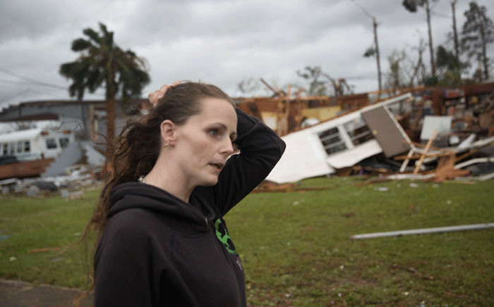 FILE: Haley Nelson stands in front of what is left of one of her father’s trailer homes after hurricane Michael passed through the area on 10 October 2018 in Panama City, Florida. Picture: AFP.