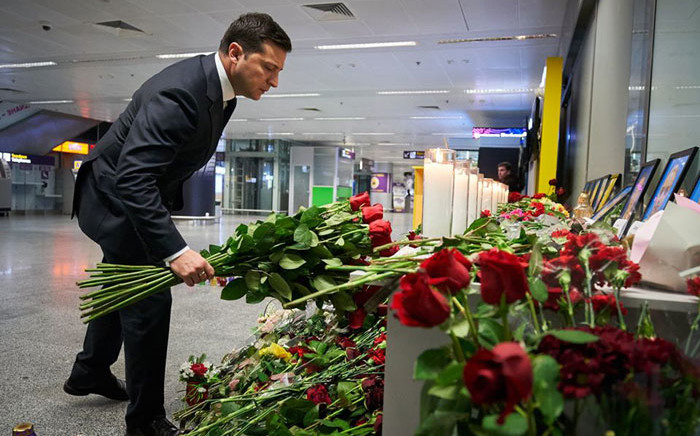 This handout picture taken and released by the Ukrainian presidential press service shows Ukraine's President Volodymyr Zelensky placing flowers at a memorial for the victims of the Ukraine International Airlines Boeing 737-800 crash in the Iranian capital Tehran, at the Boryspil airport outside Kiev on 9 January 2020. Picture: AFP