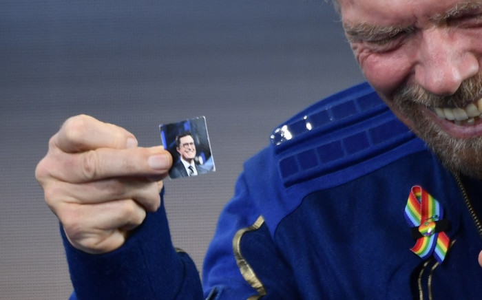Sir Richard Branson holds up a photo of comedian Stephen Colbert that he brought with him into space, as he speaks after flying into space aboard a Virgin Galactic vessel, a voyage he described as the "experience of a lifetime". Picture: AFP.