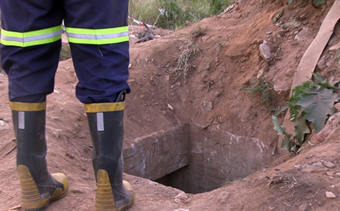 FILE: A rescue worker stands next to the illegal mine shaft where eleven miners were rescued after being trapped underground for almost a day on 16 February 2014. Picture: Reinart Toerien/EWN