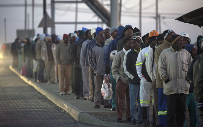 FILE: South African platinum miners queue to undergo essential medical and safety procedures before working, early on 25 June 2014 at the Wonderkop mines in Marikana Rustenburg, after a five month long strike. Picture: AFP.