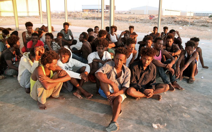Rescued migrants sit on the coast of Khoms, some 100 kilometres (60 miles) from the Libyan capital Tripoli, on 26 July 2019. Picture: AFP