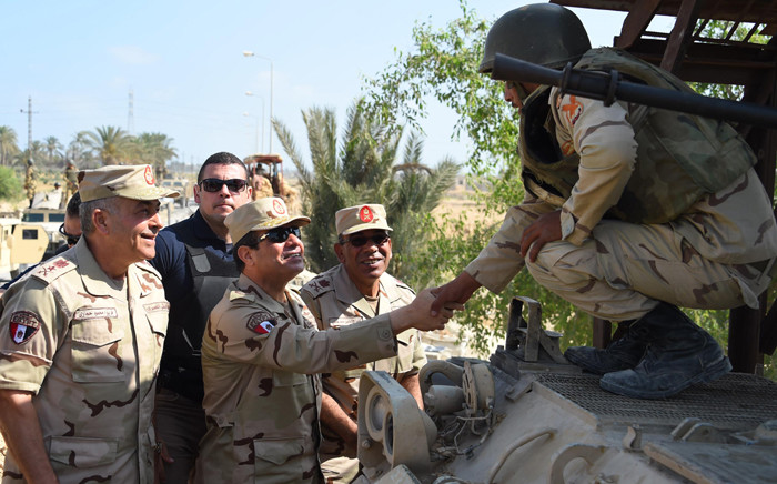 A handout picture released by the Egyptian Presidency on 4 July, 2015, shows Egyptian President Abdel Fattah al-Sisi (C) shaking hands with a member of the security forces during a visit to the Sinai Peninsula following a wave of deadly attacks on armed forces by the Islamic State jihadists. Picture: AFP.