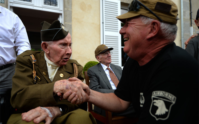 US World War II veteran Joe Riley, 98-years-old, of the 501th Airborn, shakes hands with a WWII enthusiasts, in Sainte-Marie-du-Mont, northwestern France, on June 6, 2019, during celebrations marking the 75th anniversary of the D-Day landings. Picture: AFP