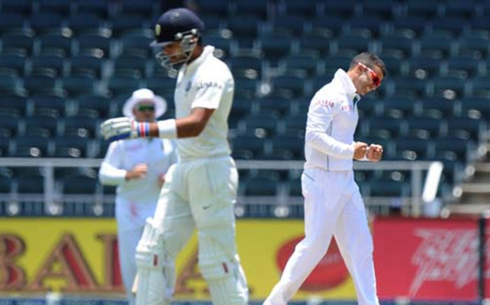 SOUTH AFRICA, Johannesburg : Indian batsman Virat Kohli (L) walks off the field after being dismissed by South African bowler JP Duminy (R) on the fourth day of the first cricket Test between South Africa and India at the Wanderers Stadium in Johannesburg on December 21, 2013. AFP PHOTO