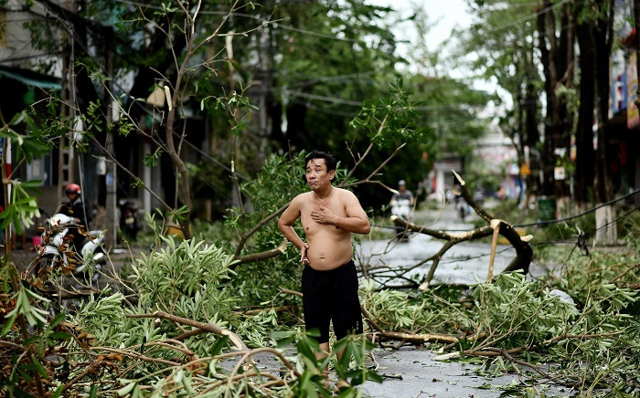 A man reacts while standing amidst uprooted trees in central Vietnam's Quang Ngai province on October 28, 2020, in the aftermath of Typhoon Molave. Picture: AFP