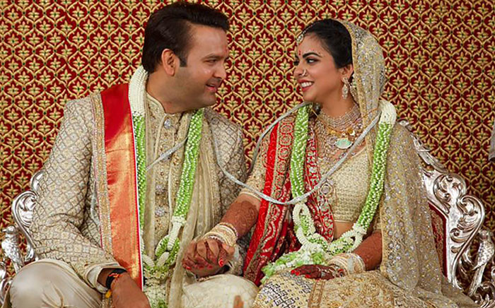 This handout photograph taken on 12 December 2018 and released on December 13 by Reliance Industries shows Reliance Industries chairman Mukesh Ambani's daughter Isha Ambani (L) taking part in traditional marriage ritual with Indian businessman Ajay Piramal's son, Anand Piramal in Mumbai. Picture: AFP.