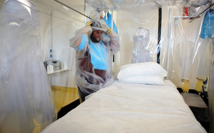 FILE:A nurse wears protective clothing as he demonstrates the facilities in place at the Royal Free Hospital in north London on 6 August 2014, in preparation for a patient testing positive for the Ebola virus. Picture: AFP.