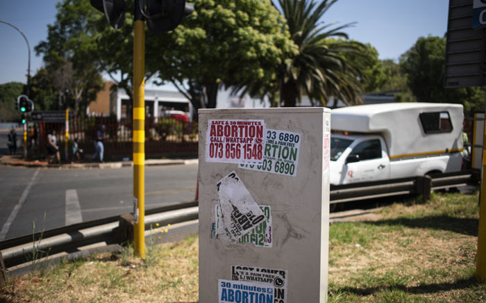 FILE: Posters advertising illegal abortion are seen on a box in Sophiatown, Johannesburg. Picture: LUCA SOLA/AFP